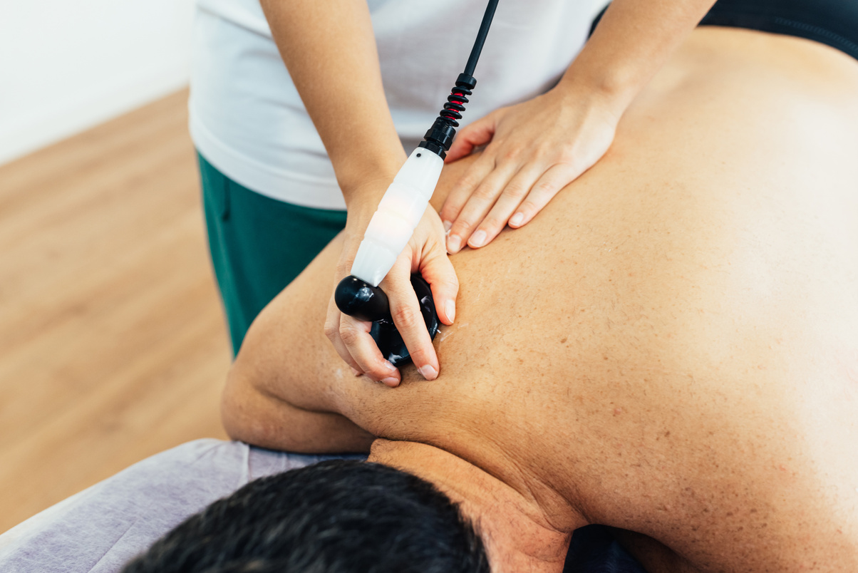 Hands of a physiotherapist treating the patient's pain with diathermy. Muscle inflammation. Health concept